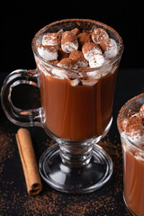 Two cups of hot chocolate, cocoa or warm drink with marshmallows on dark background