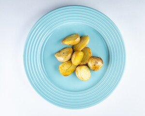 Light blue plate with potato. Baby potato top view. Side dish with potato.