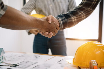 construction worker and contractor. Client shaking hands with team builder at office in the morning.