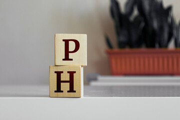 The word 'PH' written on wood cube.