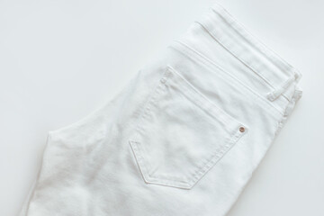 White denim pants on white background, jeans closeup, ripped denim