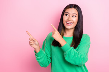 Photo of excited cheerful japanese lady look satisfied interesting option new gym opening point fingers copyspace ad isolated on pink color background