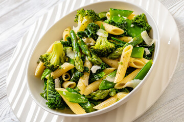 Pasta primavera with green veggies, cheese in bowl