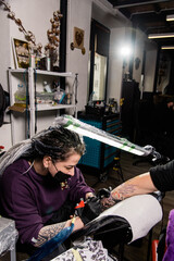 A tattoo artist makes a tattoo in a salon