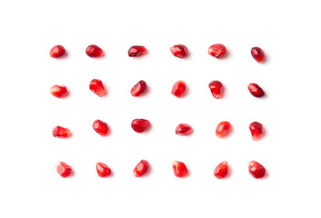 Pomegranate seeds are neatly arranged on a white background top view.