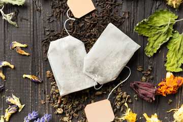 Dry green and black tea, tea bags, flower tea on a dark background top view close-up.