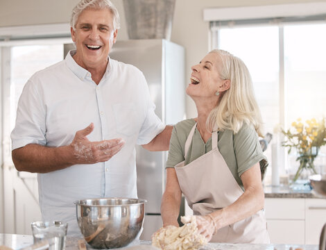Old couple baking together, happy with baker skill and spending quality time in retirement, marriage and laughter. Funny with elderly people in kitchen, trust and bonding with cooking and happiness