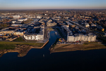 Obraz premium Noorderhaven neighbourhood at riverbed of the IJssel in Zutphen, The Netherlands, under construction. Aerial panorama industrial view of building plot. Housing and urban management real estate.