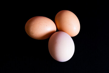 Three colored eggs on a black background