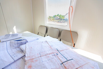 Bunch of scattered architectural blueprints, plans, drawings in office