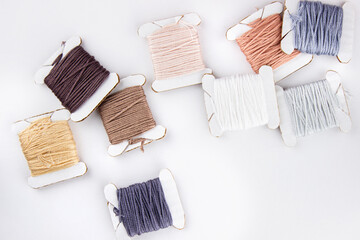 Fototapeta na wymiar Skeins of cotton threads of different colors lie in a pile on a white background