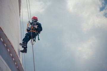 Male worker rope access  inspection of thickness  storage tank