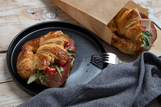 Croissant with jamon, cheese, salad and tomatoes for breakfast
