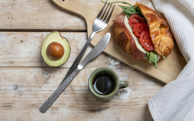 Croissant with jamon, cheese, salad and tomatoes for breakfast