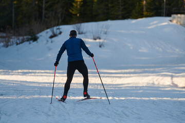 Nordic skiing or Cross-country skiing classic technique practiced by man in a beautiful panoramic trail at morning.Selective focus.