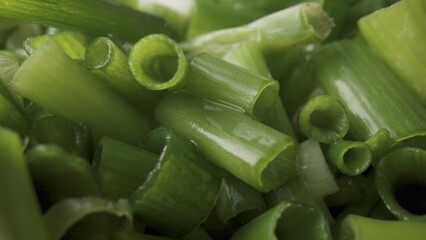 Green onion stalks cut into pieces. A heap of juicy wet chopped green onions. Seasonal greens,...