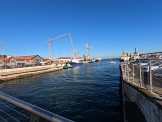 Port of Lisbon, with tug boat and cranes in the background, in a sunny day