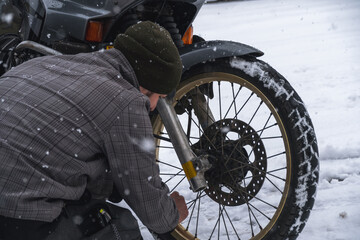 The man and his motorcycle. wheel. Rubber and tread are clogged with snow. Concept of transport and...