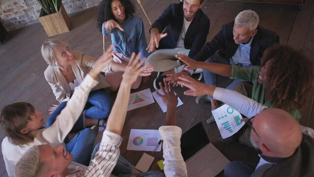 group of multiethnic creative coworkers bring hands together in unity after choosing new strategies