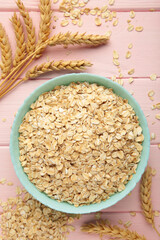 Oatmeal in bowl on pink background. Healthy eating concept.