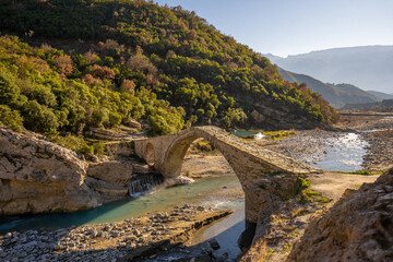 Old stone bridge with arch shape photographed during sunset. photo taken in Permet Albania