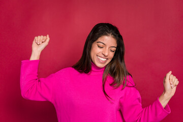 Excited woman celebrating victory against red background