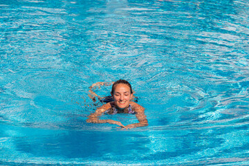 Cyprus Protoras October 11, 2021, young girl swims in the pool. close-up of a girl. relaxing in the outdoor pool in clear weather. bathing. travel.