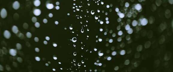 Atmospheric minimal monochrome backdrop with rain droplets on glass. Wet window with rainy drops and dirt spots closeup. Blurry minimalist background of dirty window glass with raindrops close up.