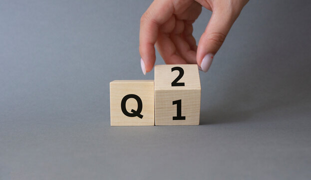 From 1st Quarter to 2nd symbol. Businessman hand Turnes cube and changes words 1st Quarter to 2nd Quarter. Beautiful grey background. Business and Quarter concept. Copy space