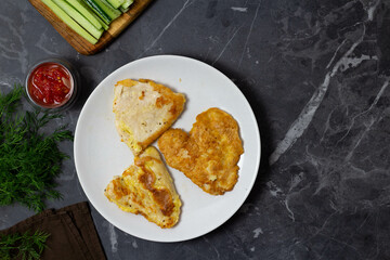 Chicken fillet in batter on a white plate. Top view.