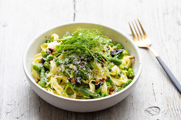 Tagliatelle pasta with asparagus, green peas and broad beans