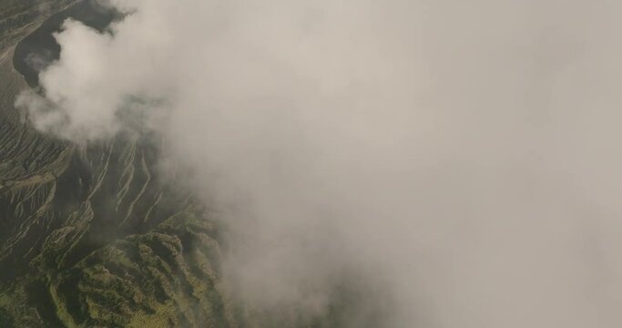 Aerial Backward Shot Of Smoke Spreading Over Volcanic Landscape - Java, Indonesia