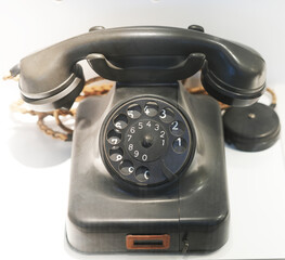 Old black phone with cradle and rotary dial. Nostalgia phone. Communication.