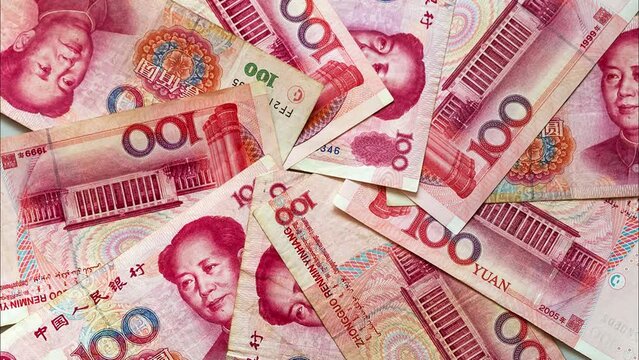 Paper money in denominations of 100 yuan are laid out in a circle on a light table. Chinese economy and finance. Currency background. The concept of finance, banking, investment, business and lending