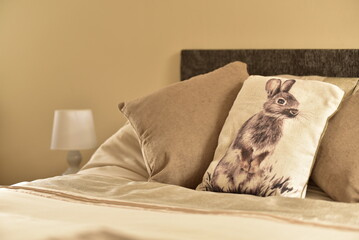 bed and pillows with table lamp and rabbit cusion. 
