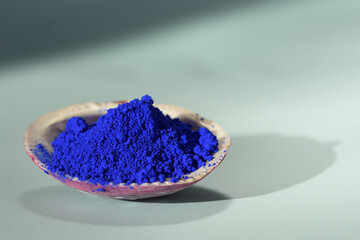 Pigmento azul cobalto dentro de una concha mostrando su textura y granulación.