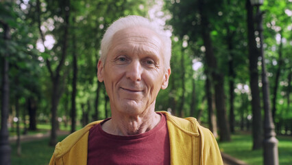 Healthy cheerful man in his 60s looking at camera with a smile on his face, vitality