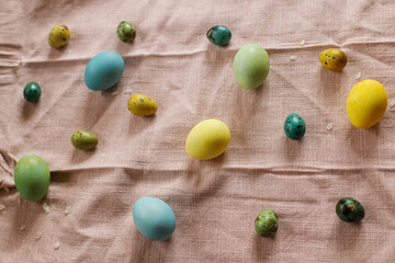 Happy Easter! Rustic easter still life. Natural painted eggs and cherry petals on pink linen fabric. Stylish easter eggs and blooming cherry flowers on rustic table.