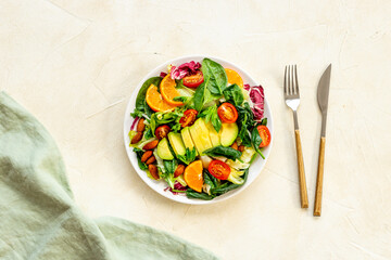 Bowl of green salad with avocado and tomatoes. Healthy vegetarian lanch