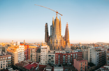 View of Barcelona Eixample residential district and Sagrada Familia Basilica at sunrise or sunset. Catalonia, Spain. Cityscape with typical urban houses