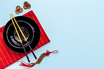 Black and gold chopsticks with red mat. Asian tabble place setting