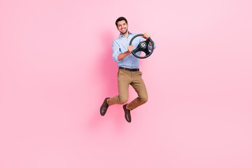 Fototapeta na wymiar Full body length photo of young jumping carefree active businessman trying drive steering wheel his new sport car isolated on pink color background