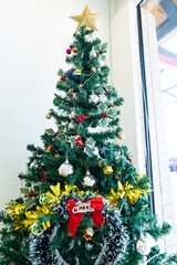 Red ribbon on the Christmas pine tree as a symbolic sign to say Merry Christmas.