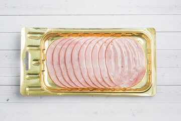 Pork ham in thin slices in a vacuum package on the table. Meat sliced carbonate in a package for...