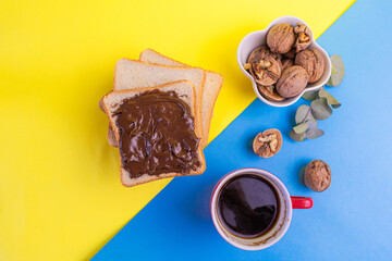 delicious breakfast with bread, walnuts and coffee, chocolate spread sandwich on color background