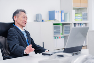 会社で自分の意見を語る管理職の男性