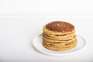 Freshly baked farinata pancakes made from chickpea flour stacked on white plate. Healthy food. Typical italian dish. Copy space for text.