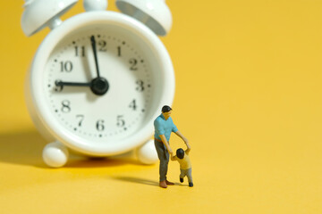 Miniature people toy figure photography. Time for children concept. A father and son standing in...