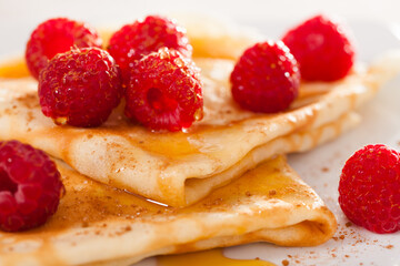 delicious pancakes with fresh raspberries and honey