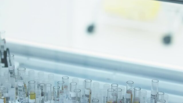 A video of a robot arm of an automated lab picking up one empty test tube and takng it away. Lab concept. High quality 4k footage